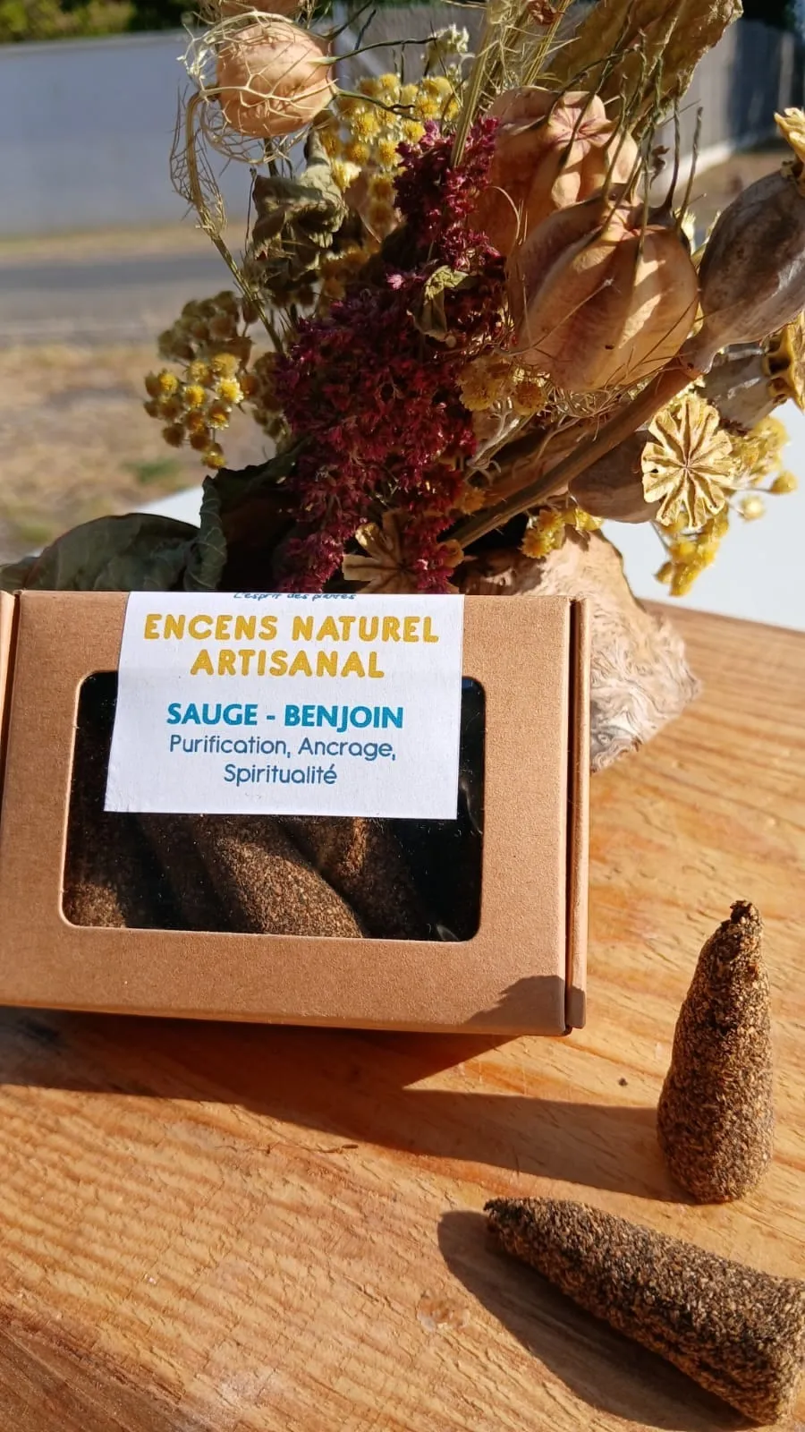 Boîte fenêtre de cônes d'encens Sauge – Benjoin devant un bouquet de fleurs séchées