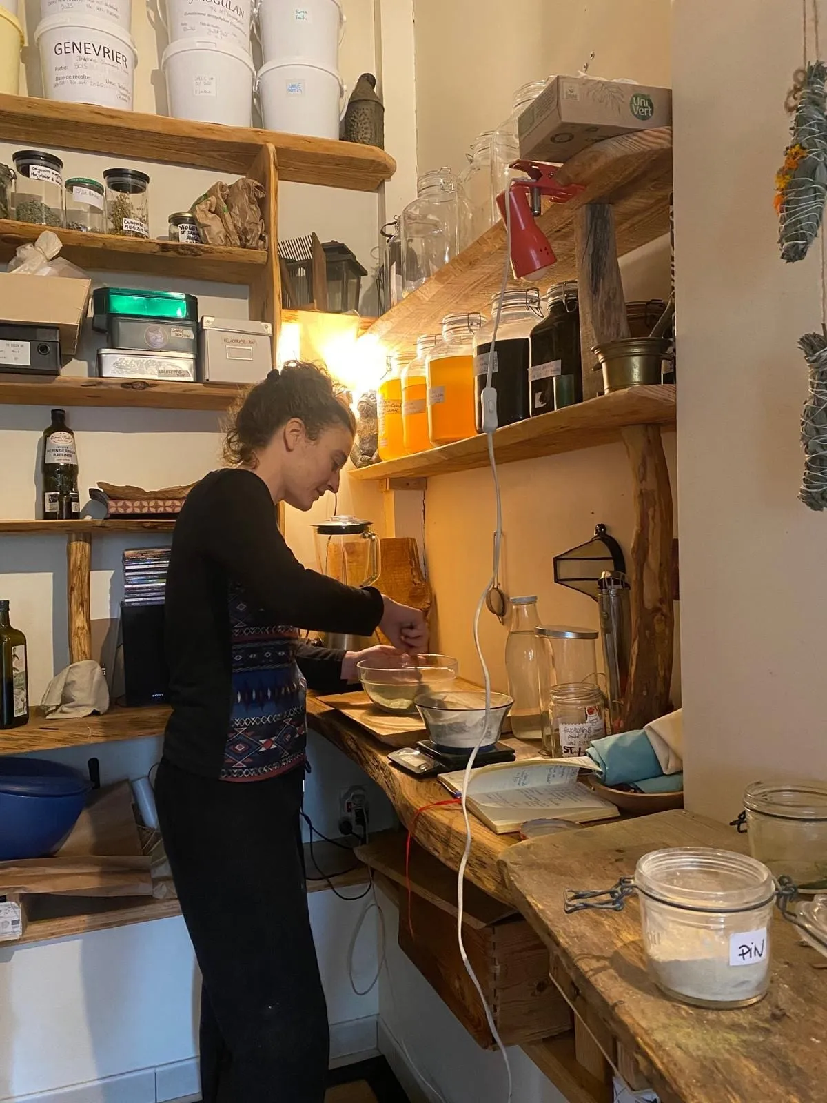 Cécile au travail dans l’atelier, entourée d’étagères de bocaux